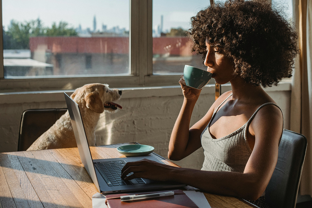 chica tomando café con un perro