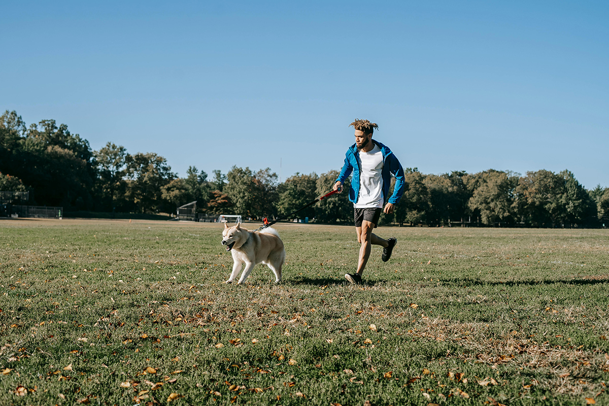 chico corriendo con el perro en el campo