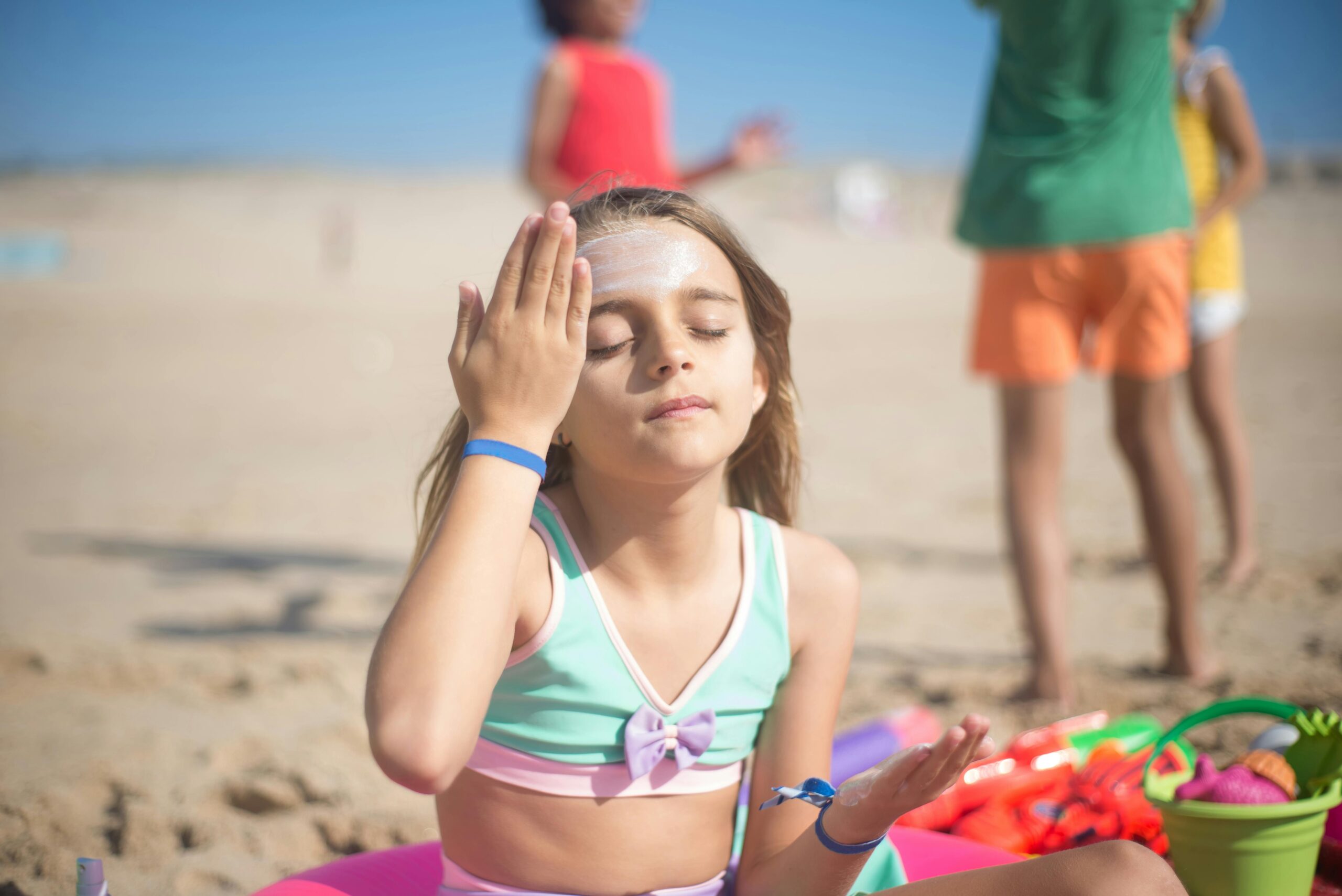 niña echándose crema en la cara