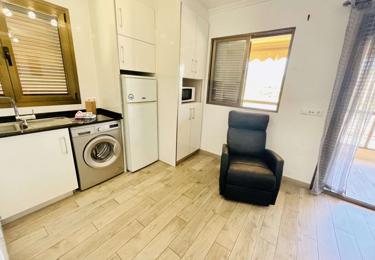 Cuisine moderne avec fauteuil dans l'appartement de vacances à La Cala de Finestrat