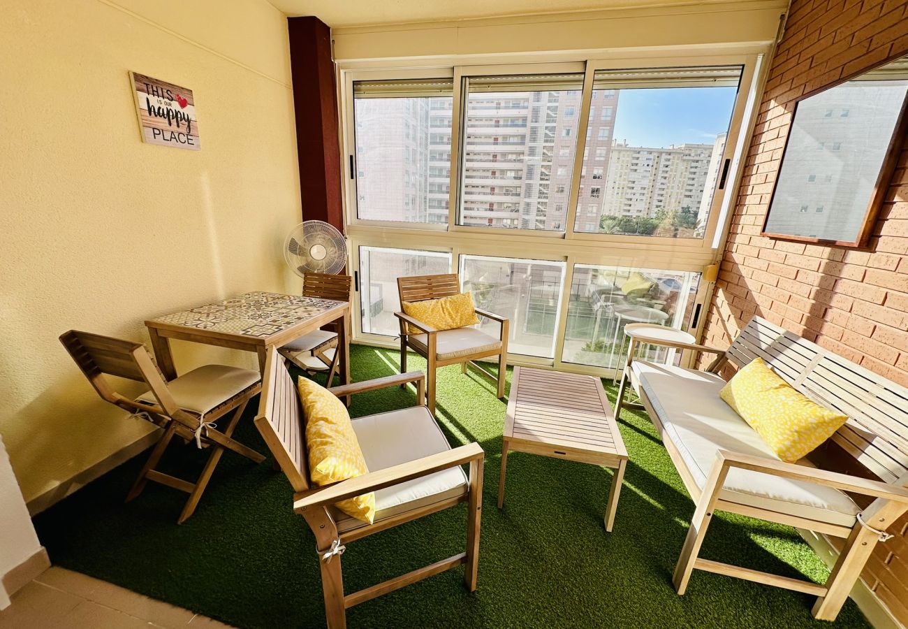 Terrasse intérieure avec tables et chaises en bois dans un appartement à Cala Finestrat